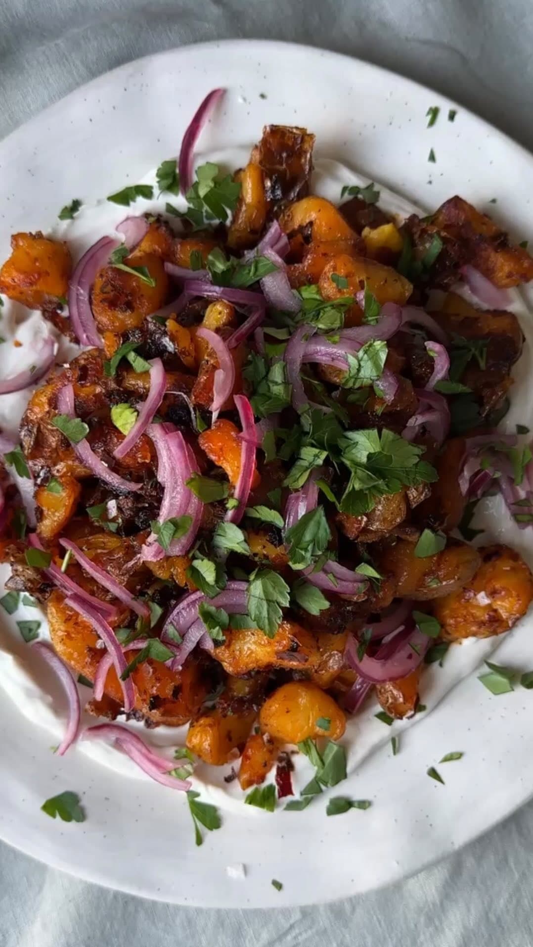 Crispy Smashed Harissa Potatoes with Garlicky Yogurt, Pickled Onions, and Parsley