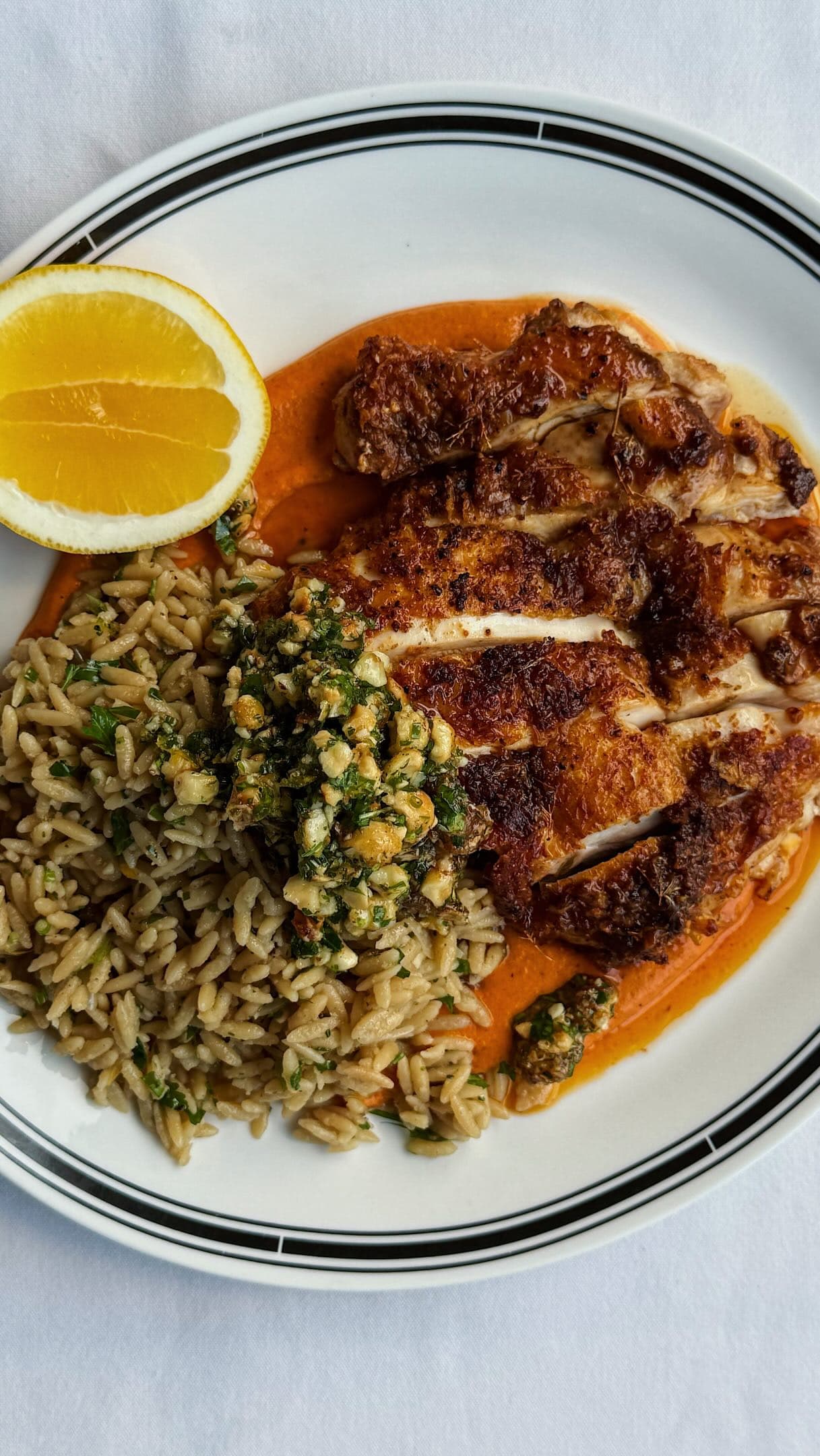 Lemon Crispy Chicken with Herby Orzo, Romesco & Candied Hazelnut Gremolata