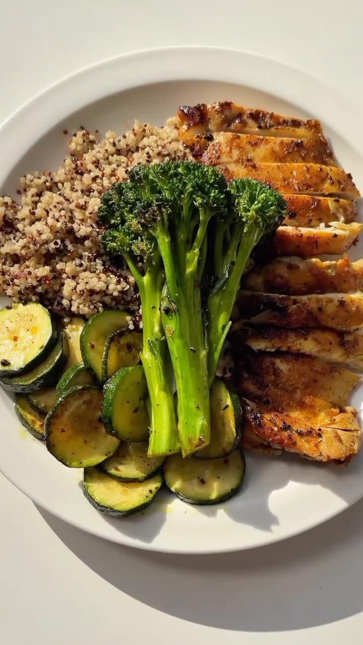 Grilled turmeric chicken with quinoa, broccolini and courgette on a white plate, from Mediterranean Diet Plan’s reel